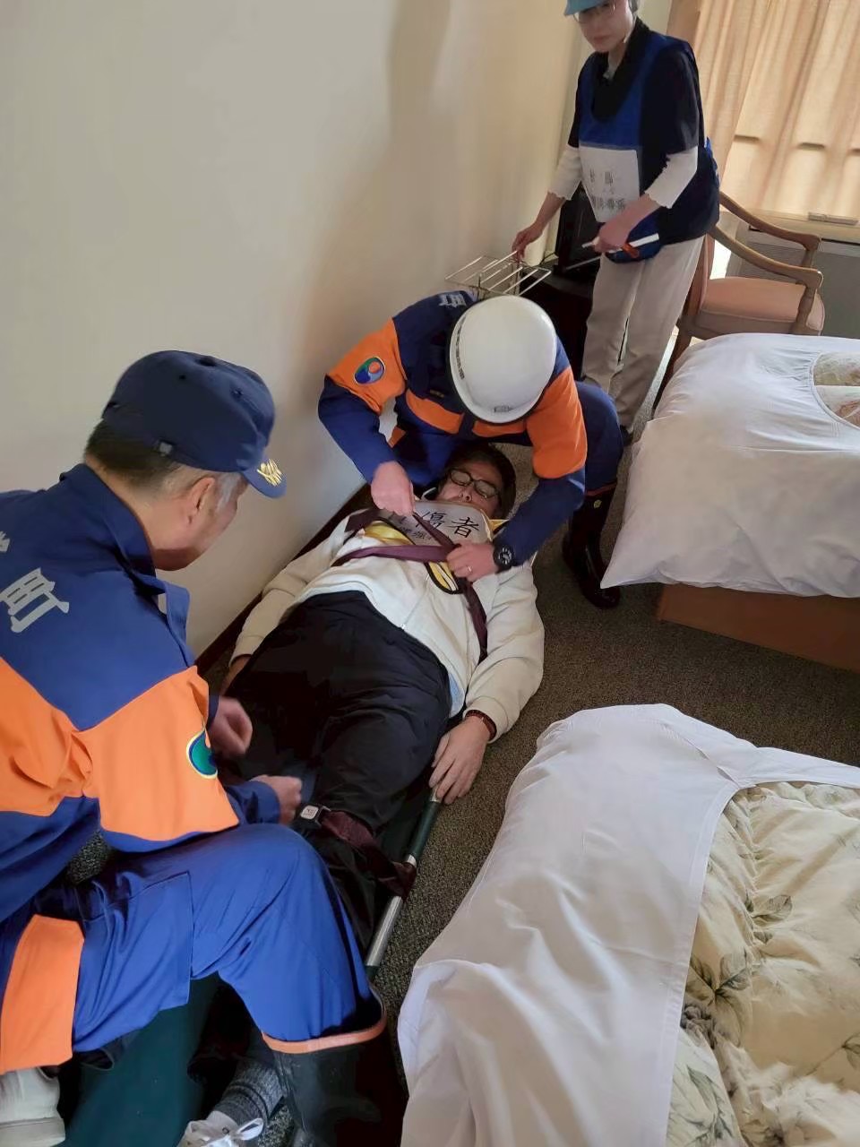 担架に載せる救護訓練の様子